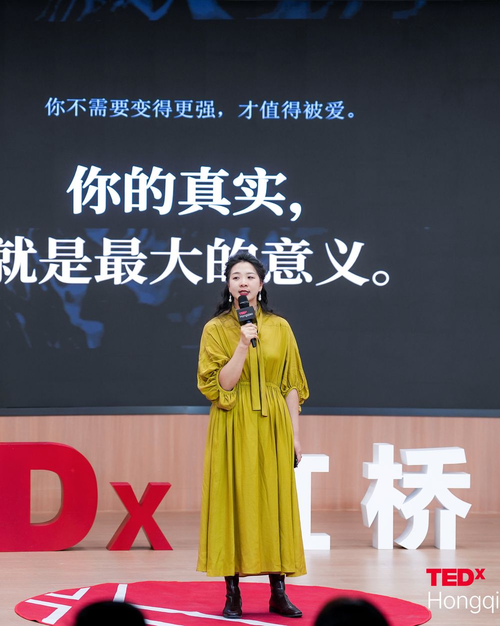 Marcia on the TEDxHongqiao Women stage in an olive dress